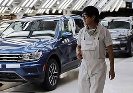 Un operario en una fábrica de México delante de varios VW Tiguan.