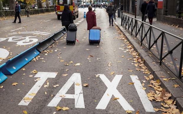 Dos personas caminan por un carril taxi de Madrid. 