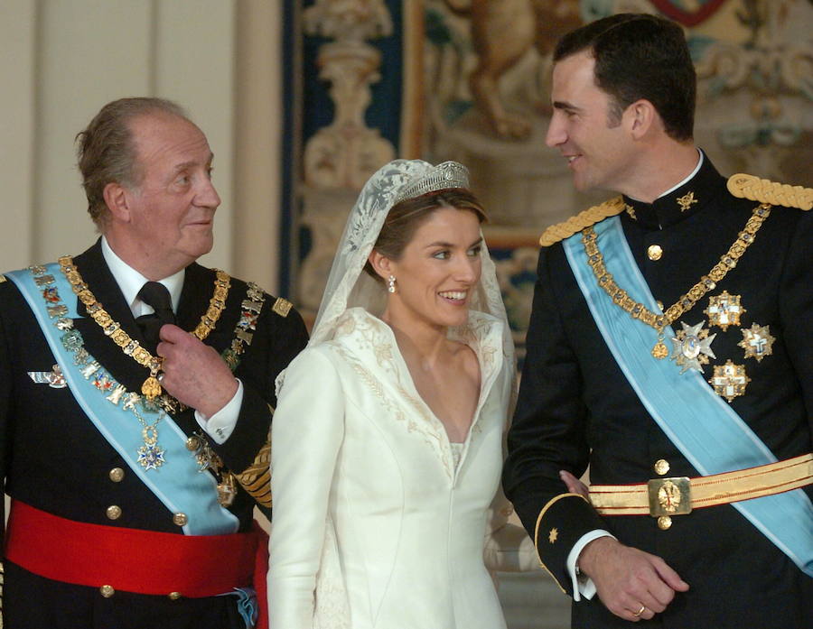 El Príncipe Felipe conversa con su padre, el rey Juan Carlos, en presencia de doña Letizia, mientras posan para la foto oficial tras su enlace matrimonial. Año 2004.