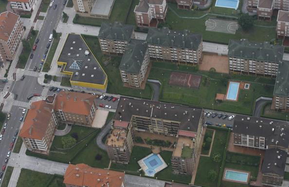 Vista aérea de varios bloques de viviendas con piscinas particulares. 