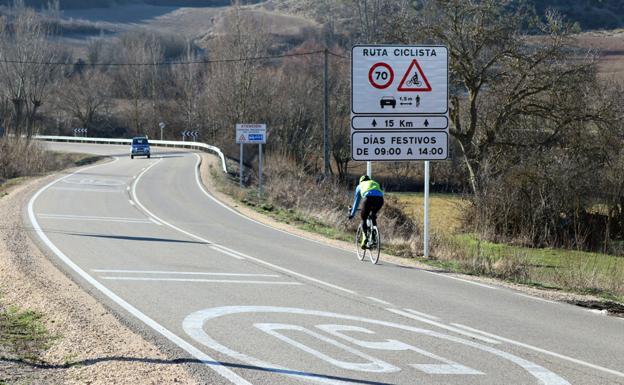 Un ciclista pasa junto al nuevo cartel que indica la entrada en una ruta ciclista segura