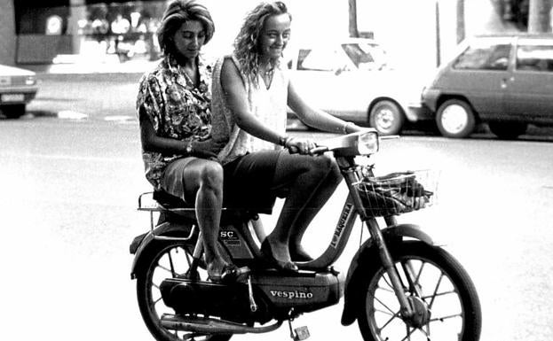 Dos jóvenes disfrutan de su vespino en una imagen de los años 70. 