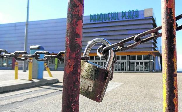 Un candado impide el acceso al aparcamiento del centro comercial de la calle Enrique Cubero. 