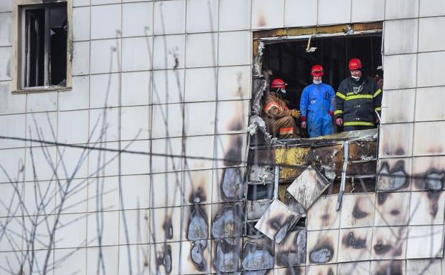 Bomberos en el centro comercial incendiado.