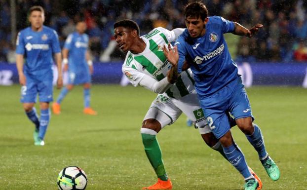 El defensa del Betis, Júnior, disputa el balón ante el jugador del Getafe, Damián Suárez.