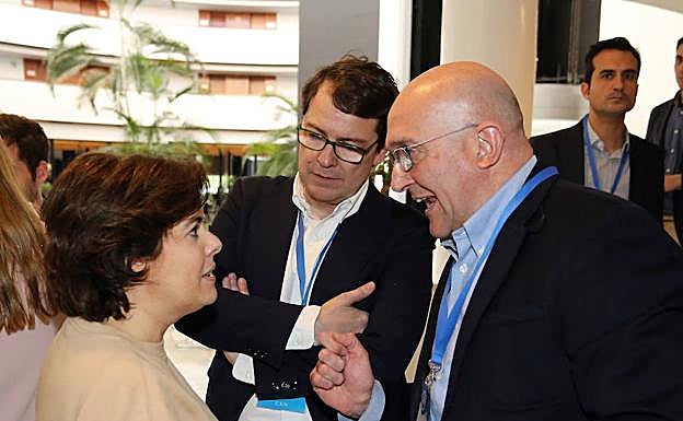 Soraya Sáenz de Santamaría, Alfonso Fernández Mañueco, y Jesús Julio Carnero conversan durante la Convención Nacional del partido en Sevilla.