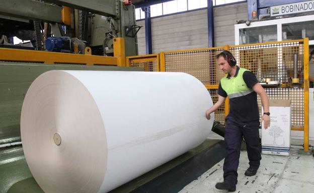 Un operario, junto a una bobina de papel estucado en la planta de Europac de Dueñas (Palencia)