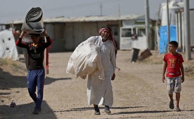 Varios refugiados caminan en el campo de refugiados Khazir, norte de Irak. 