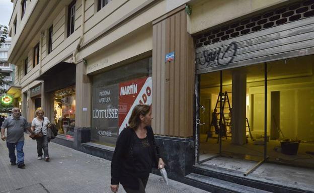 Una mujer observa los preparativos para la próxima apertura de un comercio. 