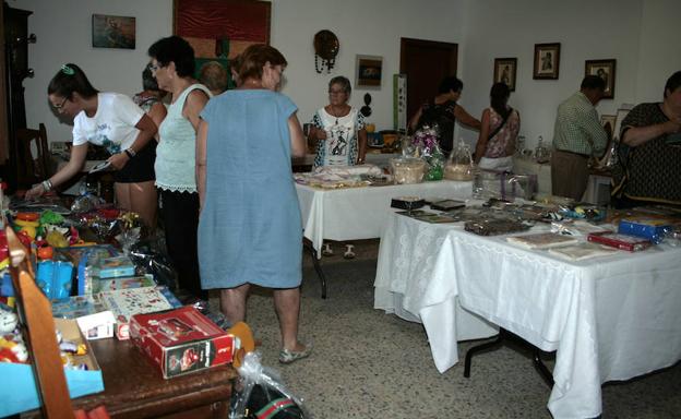 Un grupo de personas visita el mercadillo solidario a favor del retablo.