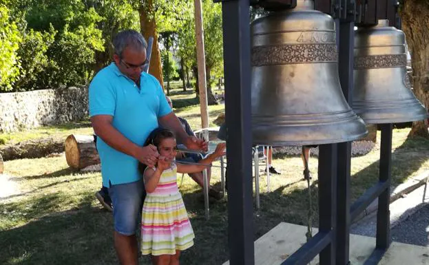 Una niña se divierte jugando a tocar las campanas.