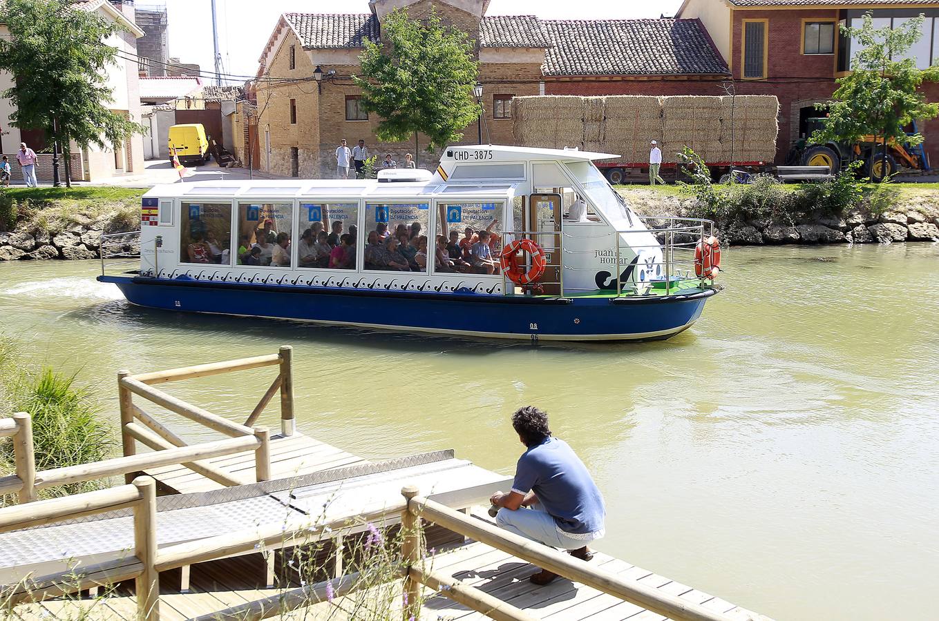 El barco Juan de Homar cruza la localidad de Becerril de Campos por el Canal de Castilla.