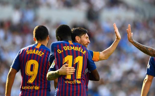 Ousmane Dembélé se abraza a Leo Messi tras un gol. 