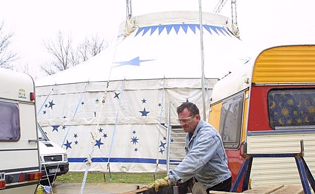 Un hombre trabaja en el montaje de una carpa de circo.