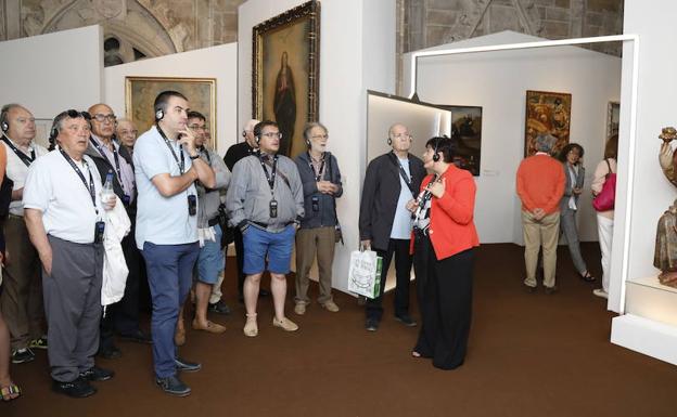 La guía Margarita Vicente explica una de las obras a un grupo en la exposición 'Mons Dei'