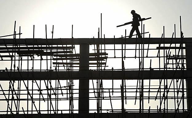 Un trabajador de la construcción porta materiales durante una obra.