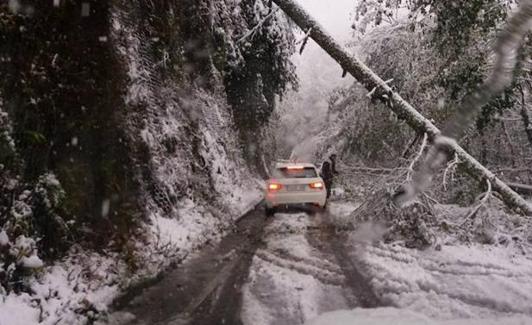 Un coche se abre paso entre la nieve en Cangas del Narcea (Asturias).