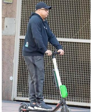 Ronaldo, en patinete circulando por una acera de Madrid. 