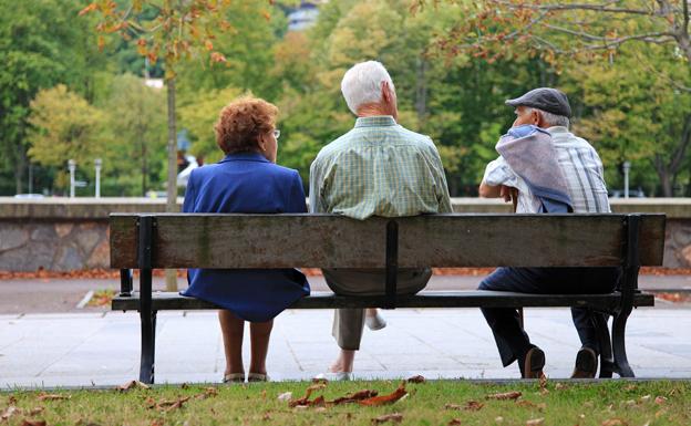 Personas mayores descansan en un banco. 