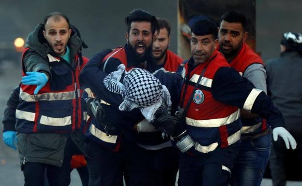 Medicos evacúan a un palestino herido durante los disturbios.