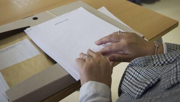 Una mujer lee en braille una papeleta de las elecciones de 2015. 