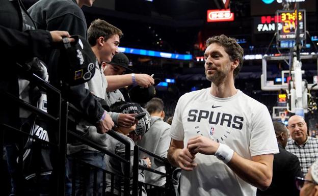 Pau Gasol firma autógrafos a varios aficionados de los Spurs.