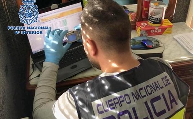 Un agente fotografía un ordenador durante la operación que ha permitido la detención de Valladolid. 