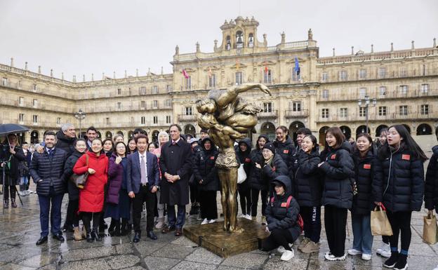 Una delegación de visitantes chinos, junto al alcalde Carlos García Carbayo y el escultor Xu Hongfei (a su lado), posan junto a la escultura situada en la Plaza Mayor. 