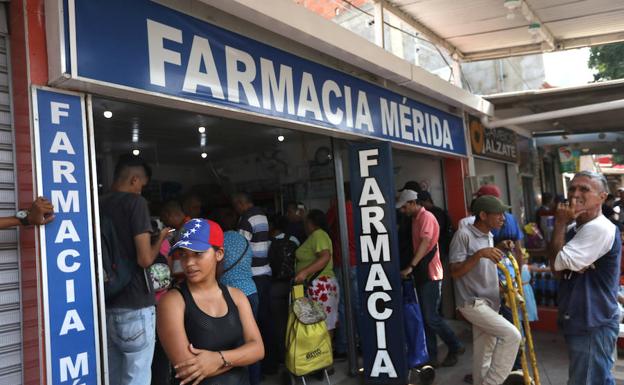 Ciudadanos hacen cola para obtener medicamentes. 