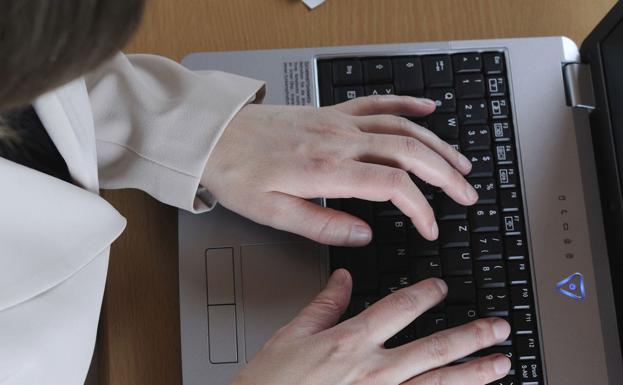 Una mujer trabaja con un ordenador portátil. 