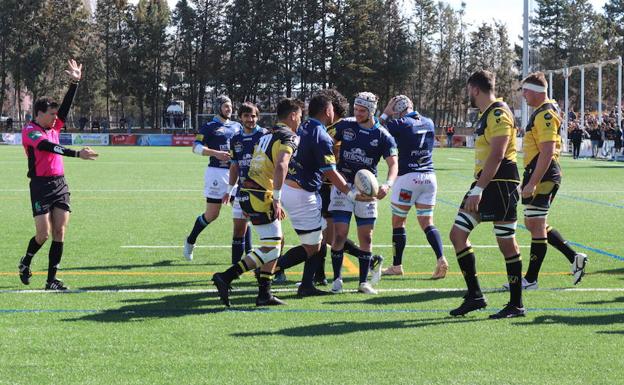 Los jugadores del VRAC Quesos Entrepinares celebran el primer ensayo del partido delante de varios hombres del UBU Colina Clinic.