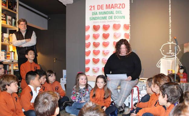Marisa Fernández, leyendo su cuento a su hija Marta y a unos alumnos del colegio Saldaña