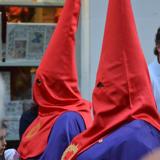 El color del capirote y la túnica es el rojo y el de la capa, el morado.