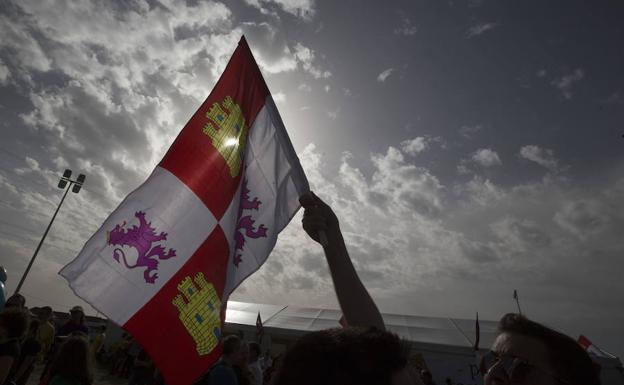 Un joven eleva una bandera de Castilla y León en Villalar. 