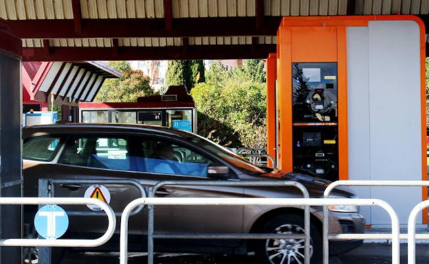 Un coche se apresta a pasar por un puesto de peaje. 