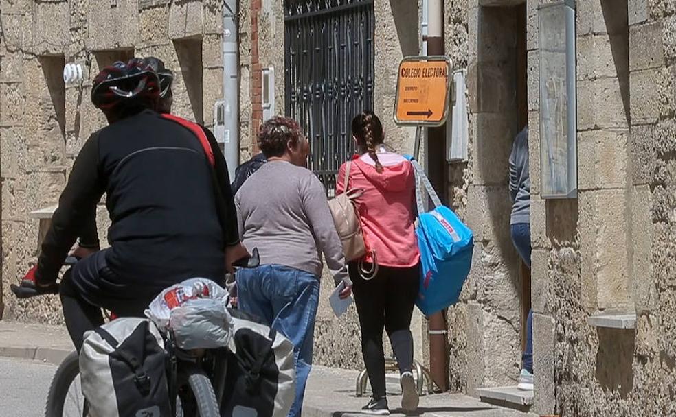 Un grupo de peregrinos en su paso por Hornillos del Camino, conocido como el 'pequeño Vaticano', mientras un grupo de personas proceden a votar