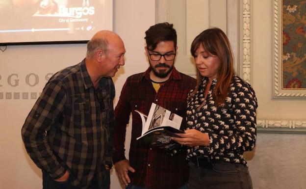 La concejala de Turismo, Carolina Blasco, lee el último de los libros de la serie 'Cuadernos de Atapuerca' acompañada por el autor del texto, Eduardo Bartolomé (centro), y el coordinador de la serie, Carlos Díez.