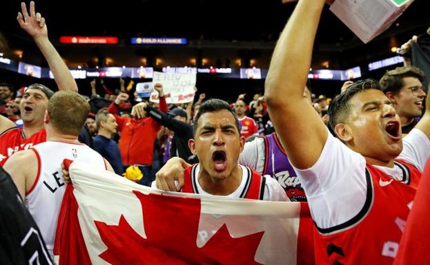 Seguidores de los Raptors celebran la victoria desde el Oracle Arena de Toronto.