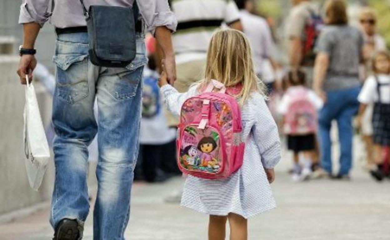 Un padre con su hija de la mano.