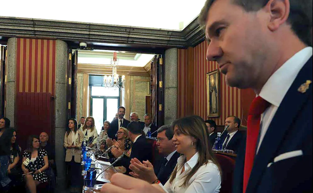 Javier Lacalle (en primer plano), portavoz del PP en la oposición, y Carolina Blasco, viceportavoz del PP, aplauden a Daniel de la Rosa al ser elegido alcalde de Burgos. 