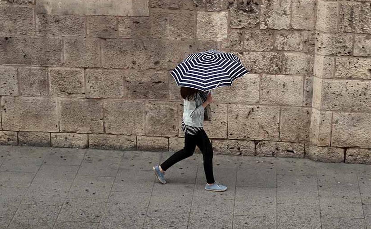 Imagen de archivo de una mujer durante una tormenta en Burgos. 