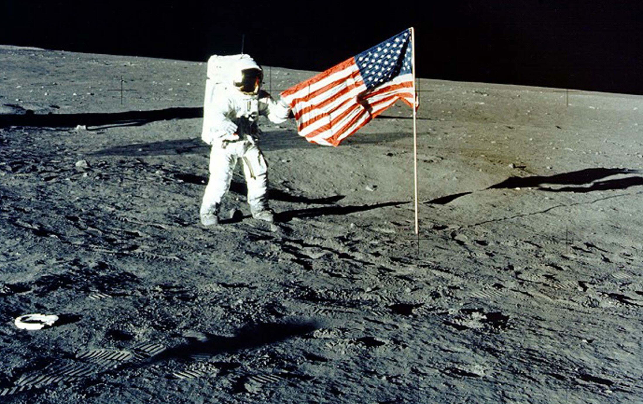 Charles 'Pete' Conrad Jr., junto a la bandera estadounidense.