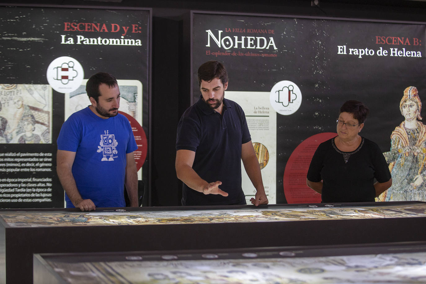 En el centro, Iván González, presidente de la Asociación Cultural ‘Villa Romana de Noheda’, explica la reproducción del mosaico que hay en el centro de interpretación del pueblo.