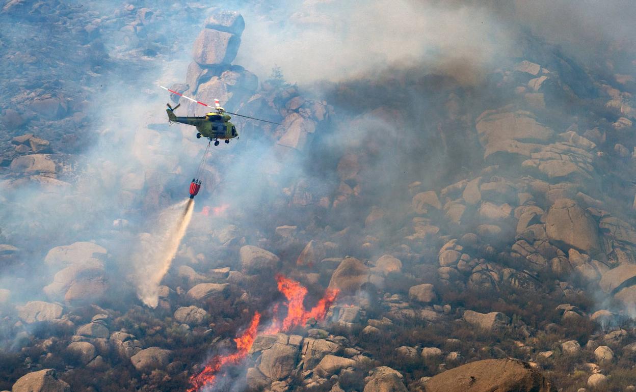 Un helicóptero trabajando en las labores de extinción del incendio declarado hoy en Navalacruz (Ávila).