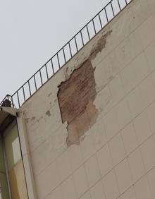 Imagen secundaria 2 - Viandantes observando la medianera (centro), los bomberos bajan un cubo con cascotes (izquierda) y aspecto de la pared (derecha).