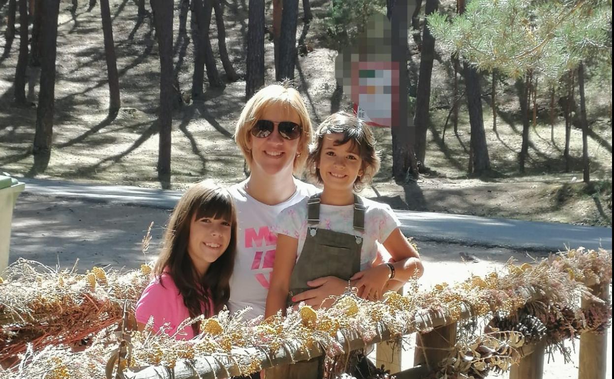 Leire Arrabal en brazos de su madre y junto a su hermana