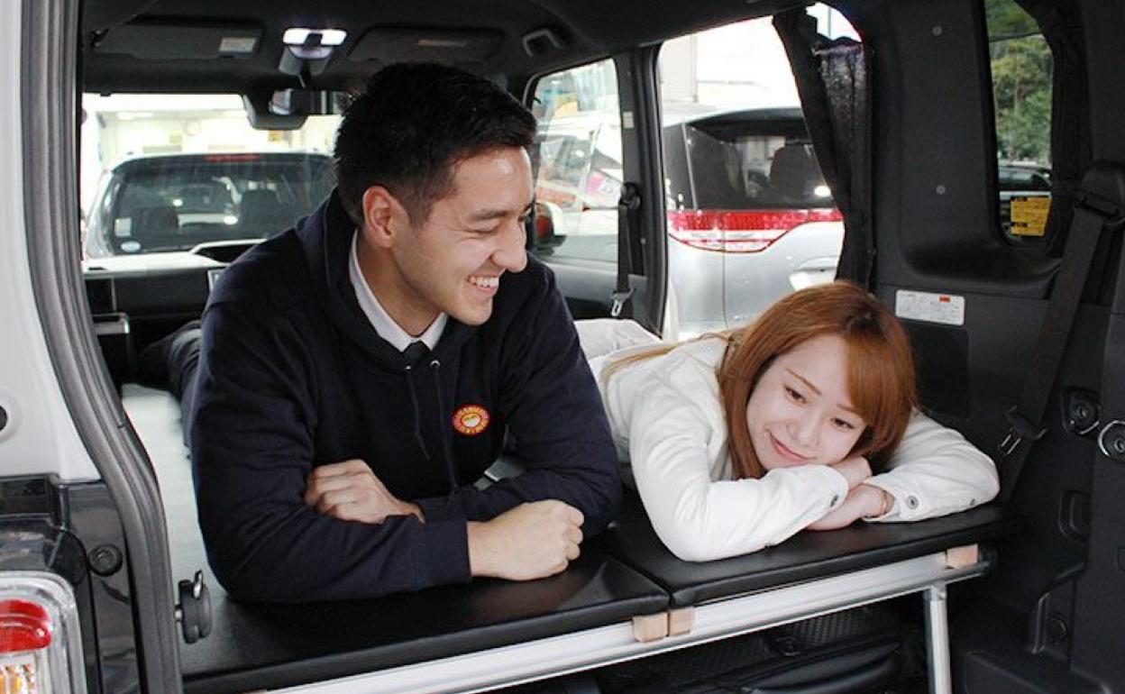 Una pareja de japoneses descansa en un coche alquilado. 