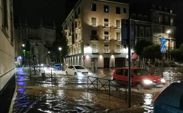 Varios coches circulan sobre balsas de agua en el centro de Valladolid.