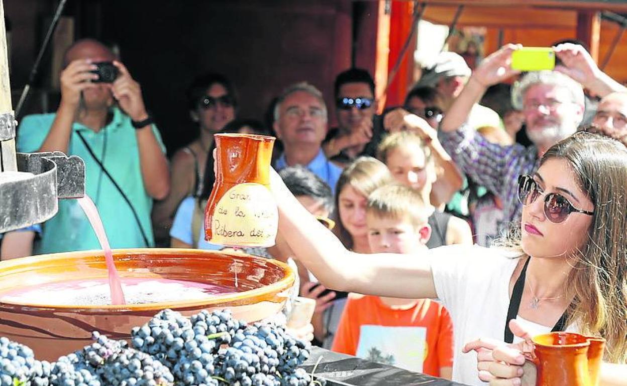 Una joven coge una copa de vino en la fiesta de la vendimia de Aranda de Duero.