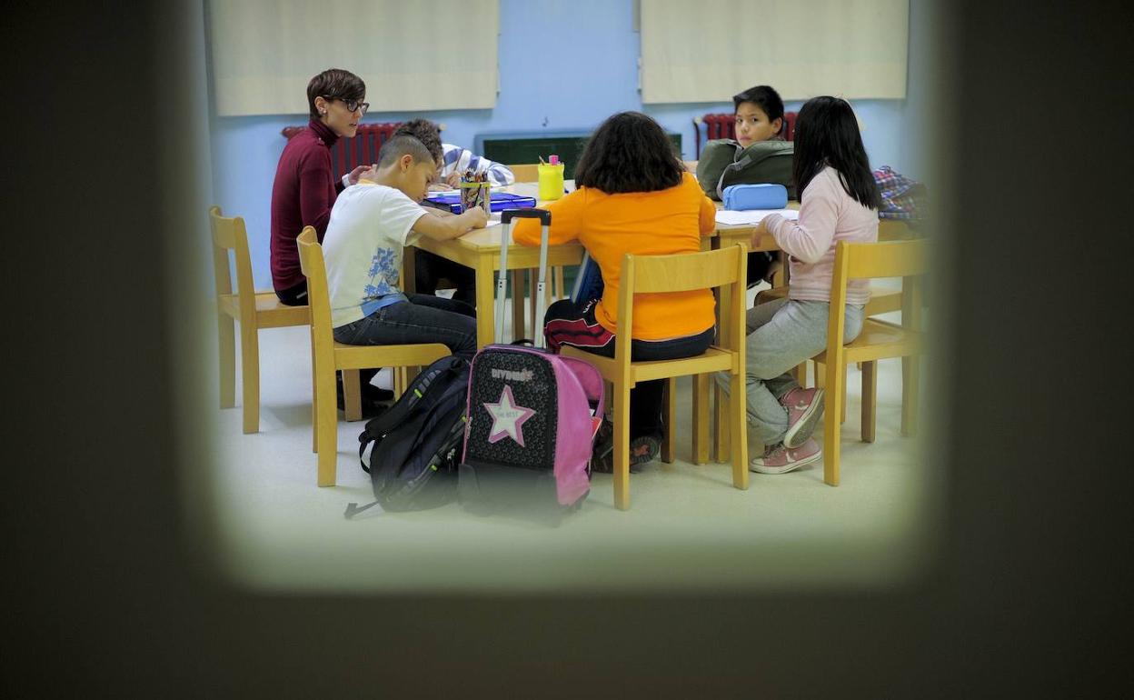 Niños cuyas familias rozan la pobreza hacen sus tareas escolares en el centro Marti-Codolar, en Barcelona.